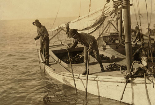 A young oyster fisher works on an oyster boat